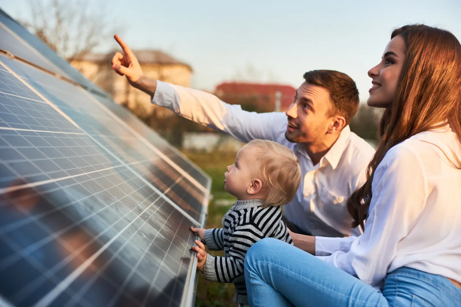Familie vor einem Einfamilienhaus mit Photovoltaikanlage